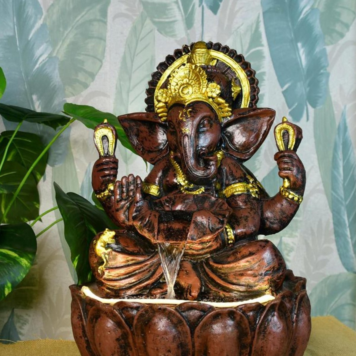 Intricately designed elegant Ganesh statues online with detailed gold accents and a flowing water feature