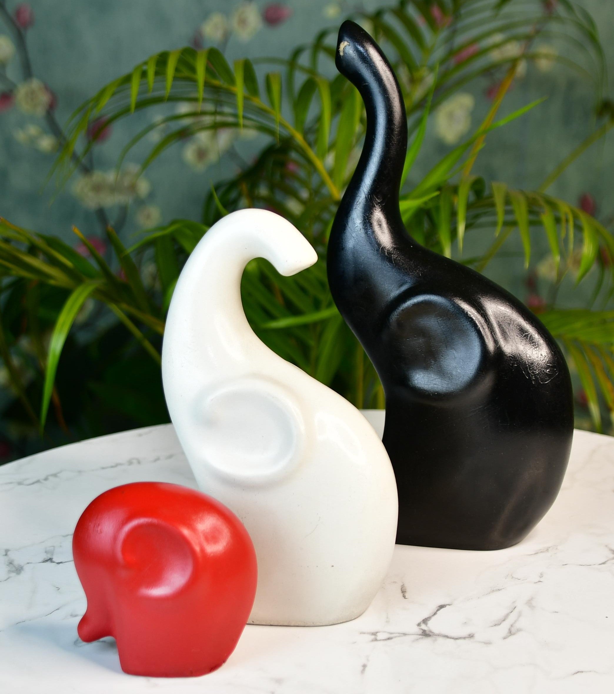 MAYII tabletop elephant home decor accents in black, white, and red on marble surface with green plants background